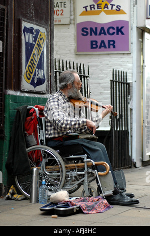 Musicien handicapé sur un fauteuil roulant jouant du violon dans les rues de Londres (fleuve) Banque D'Images