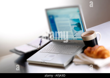 Un ordinateur portable et une grande tasse de café Banque D'Images