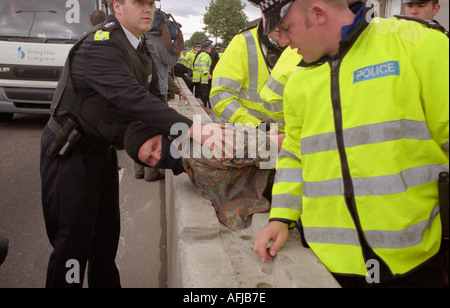 Les agents de police à l'arrestation d'un jeune manifestant à demo against arms trade fair au centre Excel de Londres. Banque D'Images