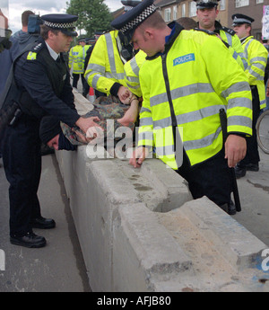 Les agents de police à l'arrestation d'un jeune manifestant à demo against arms trade fair au centre Excel de Londres. Banque D'Images