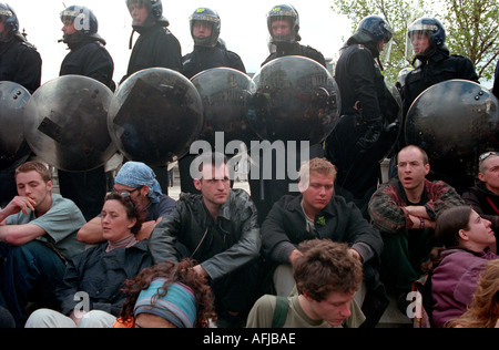 Femme manifestant est situé en face de la ligne de la police de Trafalgar Square à Londres centrale Mayday Reclaim the Streets protester en 2000. Banque D'Images