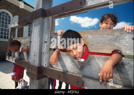 Virginia Colonial Williamsburg Duke of Glouster Street jeunes visiteurs essayant des stocks pillory Banque D'Images