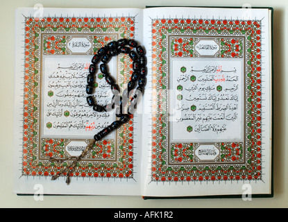 Une copie du texte sacré de l'Islam Coran ouvert en lecture avec chapelet appelé Tasbeeh Banque D'Images