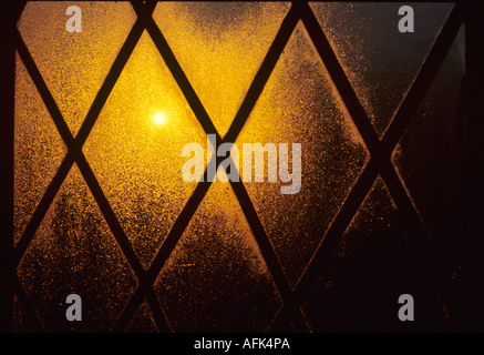 La condensation sur les fenêtres triples diamant lumière allumée par la fenêtre au plomb soleil matinal. Banque D'Images