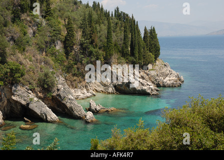 Petite église abandonnée sur l'éperon rocheux avec de grands arbres derrière, près de la plage de Nissaki, Corfu, Grèce Banque D'Images