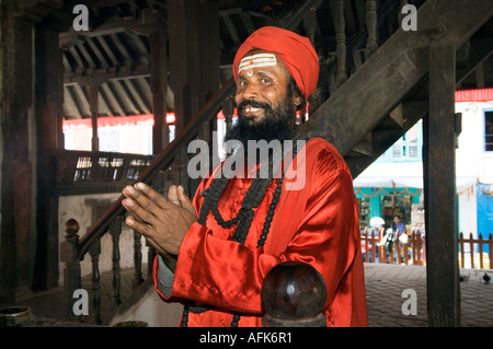 Siddhu habillé rouge sadhu saint homme Patan Durbar Square Kathmandou temples Népal Katmandou sourire saddhu ethniques d'Asie Banque D'Images