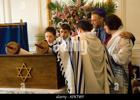 Bat Mitzvah girl (lits) lecture de la torah, aux côtés de ses parents,le rabbin et son frère, le garçon de mitzvah de barre Banque D'Images