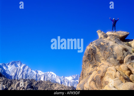 Grimpeur sur le dessus du sommet de roche avec bras levés Parution Modèle Photo Banque D'Images