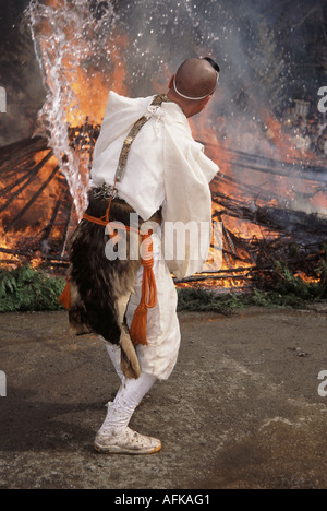 Un prêtre Yamabushi ou la montagne se jette l'eau sur les flammes au cours de l'Hiwatari matsuri sur le Mont Takao, Tokyo, Japon Banque D'Images