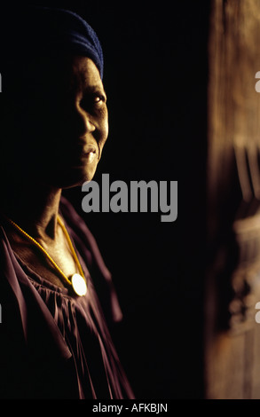 Une femme Dogon se tient dans l'embrasure d'une traditionnelle maison d'adobe dans le village d'Ende. Banque D'Images