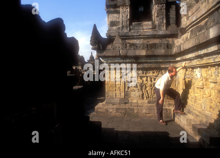 L'homme à la recherche de sculptures sur pierre au temple bouddhiste de Borobudur dans le centre de Java en Indonésie a publié le modèle de droit Banque D'Images