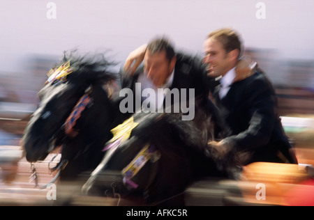 Deux coureurs sur l'effectuer le abracats correr (embrasser) galopant à travers la foule. Banque D'Images