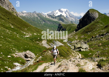 Trekker femme sur le Tour du Beaufortain la voie par la Combe de la Neuva, Alpes, avec le Mont Blanc derrière Banque D'Images