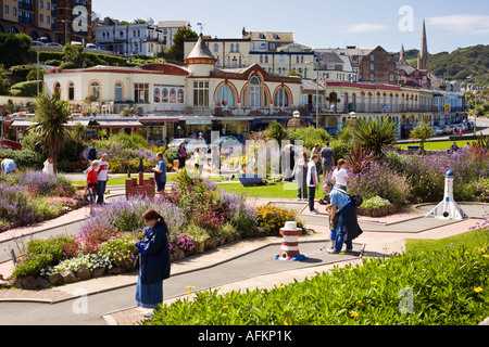 Les touristes et vacanciers jouant du mini-golf ou Mini-golf à la ville en bord de mer sur la promenade à Ilfracombe, Devon, UK Banque D'Images