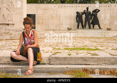 Girl écrit un sms au panthéon du mouvement de la classe ouvrière en monument Cimetière Kerepesi au centre de Budapest, Hongrie UE Banque D'Images