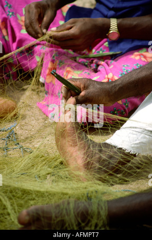 Kerala Inde pêche Vizhinjam pied de fisherman mending moustiquaires Banque D'Images