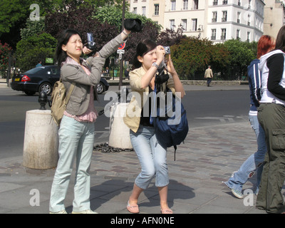 Les touristes asiatiques de prendre des instantanés de scène parisienne Paris France Banque D'Images