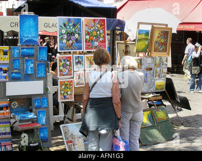 Les touristes à la recherche de fleurs colorées collection de peintures exposées à la Place du Tertre, Montmartre Paris France Banque D'Images