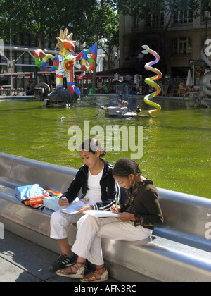 Deux filles de l'école de dessin à fontaine Tinguely colorés à la place Igor Stravinsky Paris France Banque D'Images