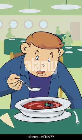 Jeune homme de manger la soupe et à la recherche à une abeille Banque D'Images