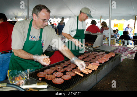 La cuisson des hamburgers sur un gril pendant à la vente lors d'un festival Banque D'Images