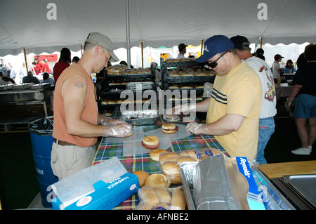 La cuisson des hamburgers sur un gril pendant à la vente lors d'un festival Banque D'Images