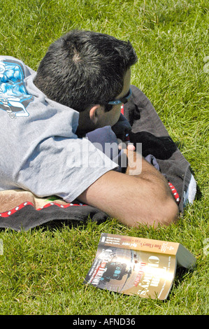 Mâle adulte lit un livre pour la détente Banque D'Images