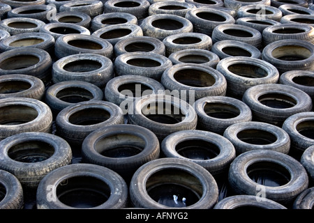 Voiture en caoutchouc usé des pneus d'automobile, des pneus en un tas utilisé pour maintenir en place des feuilles de plastique sur l'ensilage Banque D'Images