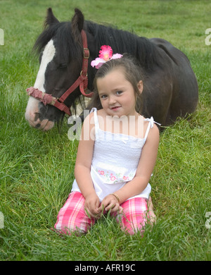 Mon Petit Poney. Gitane assise avec un poulain de 1 an dans l'herbe Banque D'Images