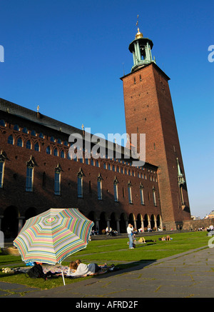 Les gens se reposer à l'ombre sous un parasol devant la mairie de Stockholm Suède Banque D'Images