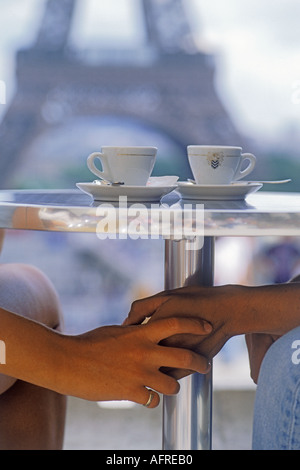 Couple holding hands sous table avec les tasses de café au restaurant du Palais de Chaillot Palais de Trocadéro de Paris Banque D'Images