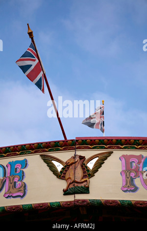 Drapeau de l'Union volant sur le dessus du carrousel à la foire du village anglais Banque D'Images