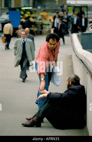 Homme donnant de l'argent à un homme sans abri, une personne âgée près de London Bridge. Ville de Londres, mode de vie contrasté. Londres Royaume-Uni années 1992 1990 HOMER SYKES Banque D'Images