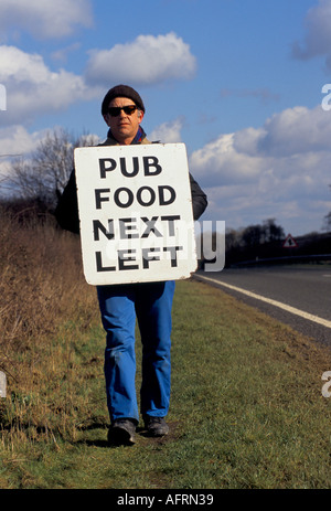 SANDWICH BOARD MAN ANNONÇANT LA CUISINE DE PUB LOCAL À GAUCHE WILTSHIRE HOMER SYKES Banque D'Images