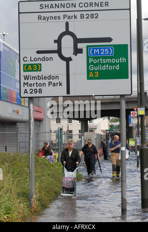 Les gens marchant dans une rue de banlieue inondée peu après des pluies torrentielles et inondations. Banque D'Images