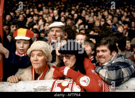 Sortie en famille au stade de football Kop stands Anfield. Les fans de Liverpool des années 1980 portent la couleur du club. Supporters dans les terrasses à un seul niveau Kop 1983. Banque D'Images