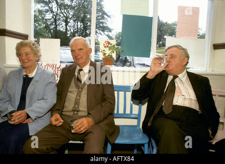 Homme buvant un verre d'eau de soufre, il est censé nettoyer une gueule de bois et nettoyer le corps. Comté de Lisdoonvarna Clare Eire. 1990s. HOMER SYKES Banque D'Images