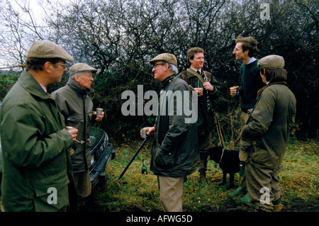 Gibier Bird Shoot domaine privé Burley on the Hill Leicestershire années 1980 Royaume-Uni les hommes boivent des gobelets en argent. Joss Hanbury propriétaire 2ème fr rigt Banque D'Images