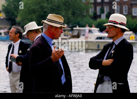 Des hommes d'âge moyen des années 1980 parlent en portant des chapeaux de paille bleu blazers à la régate royale de Henley. Henley on Thames Oxfordshire 1985 Royaume-Uni HOMER SYKES Banque D'Images