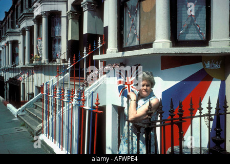 Une femme se tient en dehors de son sous-sol décoré le plat du jubilé de la reine Elizabeth II est de Londres 1977 HOMER SYKES Banque D'Images