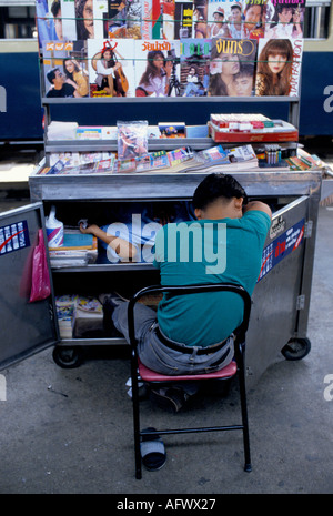 Sleeping magazine vendeur de journaux stand, il est endormi avec l'ami Bangkok gare ferroviaire Thaïlande Asie du Sud-est.1990 HOMER SYKES Banque D'Images