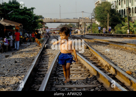 Bidonvilles personnes vivant dans la pauvreté dans un camp de squatter la ligne de chemin de fer à l'extérieur de la gare principale de Bangkok marchant dans la ville pour travailler Thaïlande ANNÉES 1990 19991 Banque D'Images