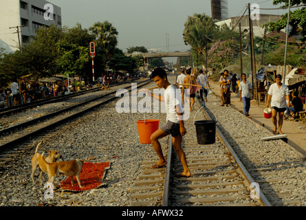 Taudis les gens vivant dans la pauvreté le long de la ligne de chemin de fer à l'extérieur de la gare de Bangkok marchant dans la ville pour travailler Thaïlande années 1990 HOMER SYKES Banque D'Images