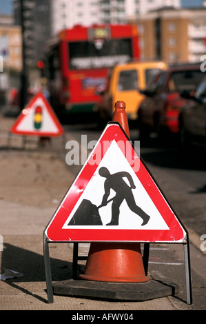 Hommes au travail panneau routier triangulaire rouge, panneau de feux de circulation temporaires. Embouteillages centre de Londres Angleterre années 2001 2000 Royaume-Uni HOMER SYKES Banque D'Images