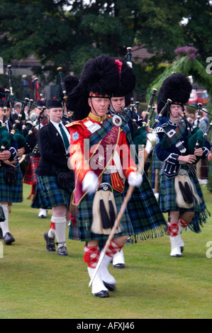 Ballater and District Pipe Band dirigé par tambour major Norman Balfour en rouge Banque D'Images