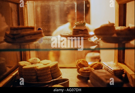 Femme travaillant dans une boulangerie de nuit à La Havane Cuba vu à travers la fenêtre avec les produits de boulangerie dans le premier plan Banque D'Images