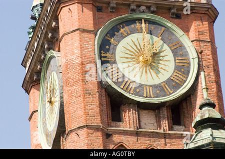 Gros plan de la vieille horloge ornée de Stary Ratusz (ancien hôtel de ville) sur la rue Dluga long, Gdansk, Pologne, avec des aiguilles dorées et des chiffres romains. Banque D'Images