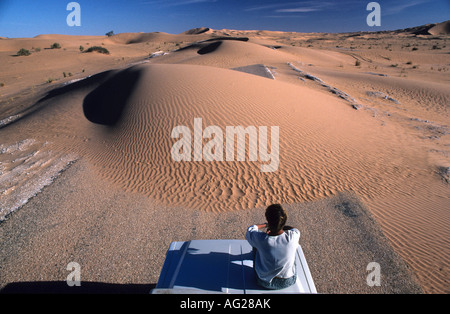L'Algérie Deb Deb Woman sitting on car avec le sable de la route bloquant Banque D'Images