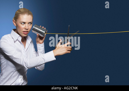 Femme ligne de coupe sur tin can string phone, sur un fond sombre Banque D'Images