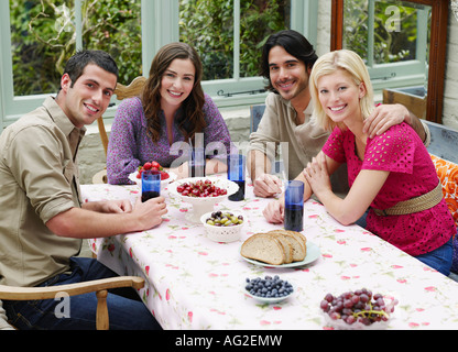Groupe de jeunes gens assis au Verandah table, view, portrait Banque D'Images